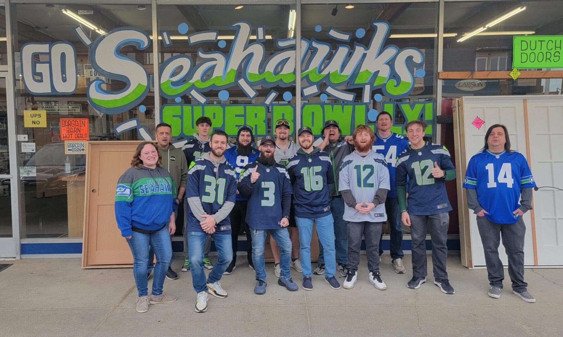 Group wearing Seahawks jerseys outside store.
